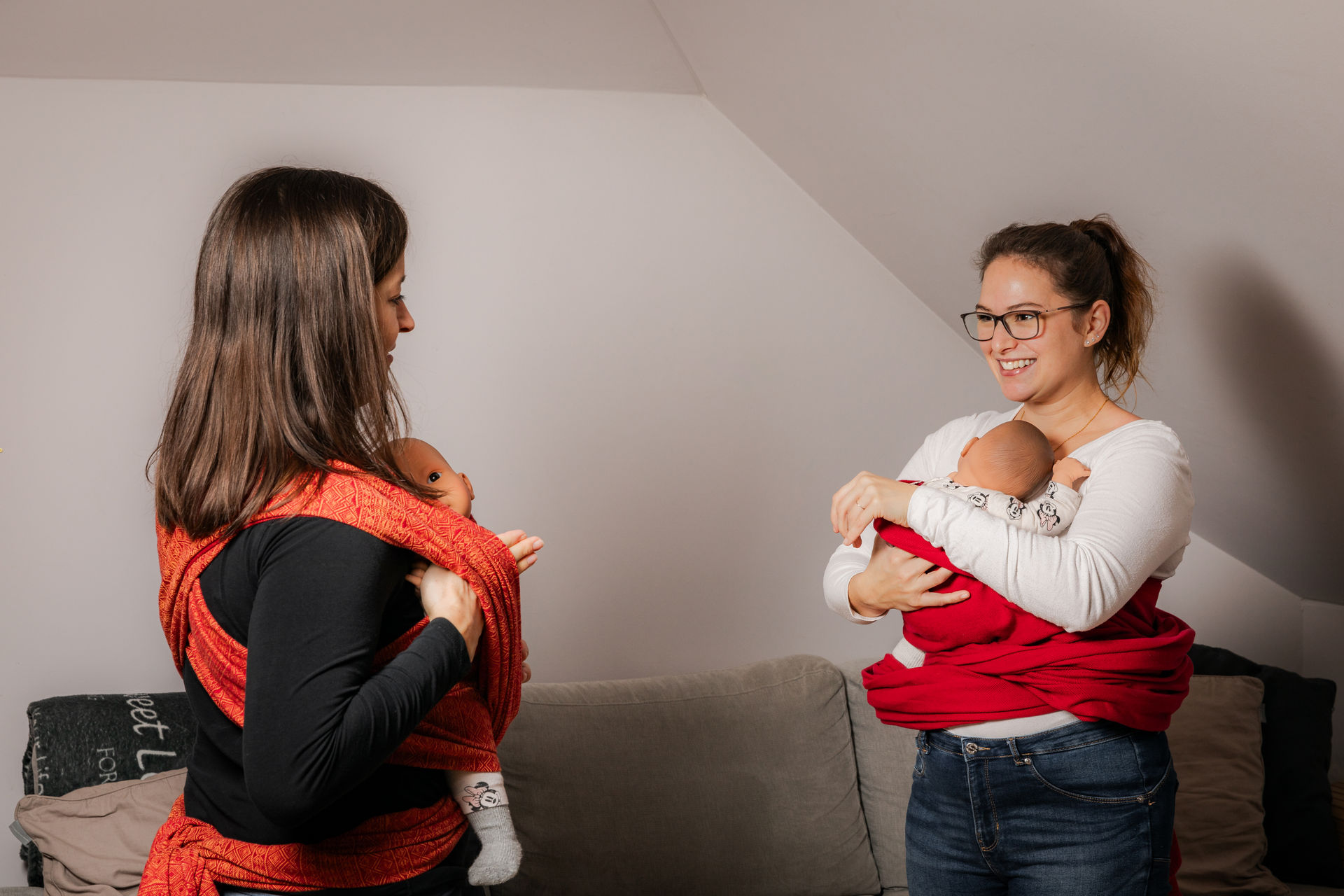 Trageberaterin von SchaukelHerz zeigt einer Kundin, wie sie ihr Baby schnell und sicher aus einem gewebten Tragetuch herausnimmt – praktische Anleitung in der 1:1 Beratung.