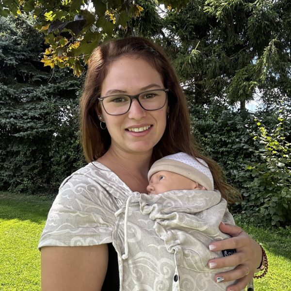 Frau trägt ein Baby in einem gewebten Tragetuch mit Sternenmotiv